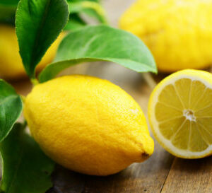Citrons entiers et découpés présentés sur une table en bois