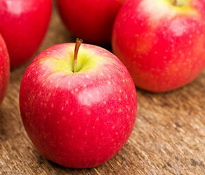 Pomme pink lady rouge sur une table en bois