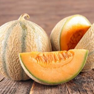 Melons charentais présentés avec une tranche, présentés sur une table en bois - fruit frais
